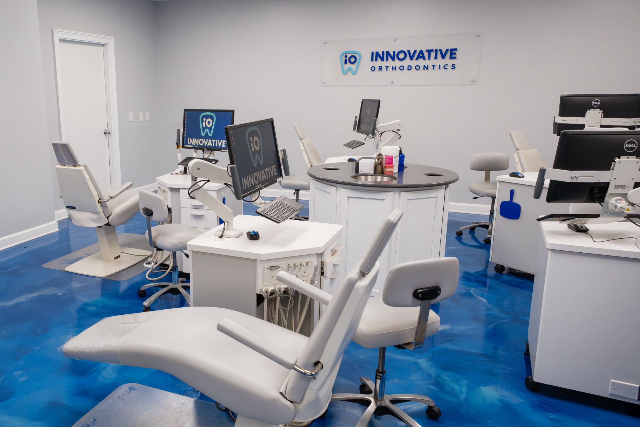 Innovative Orthodontics office interior with modern dental equipment and blue resin floor.